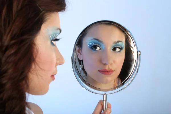 Piękna kobieta z makijażu, patrząc w lustro — Zdjęcie stockowe