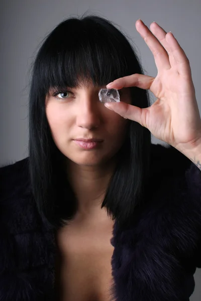Giovane donna in pelliccia con cubetto di ghiaccio posto del suo occhio — Foto Stock
