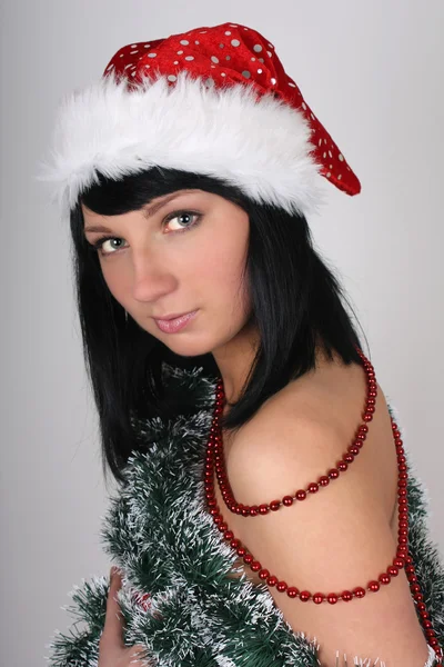 美丽的黑发女人圣诞老人帽的圣诞树摆件 — 图库照片