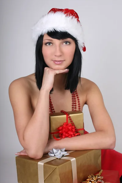 Jovem mulher com chapéu de Papai Noel com presentes — Fotografia de Stock