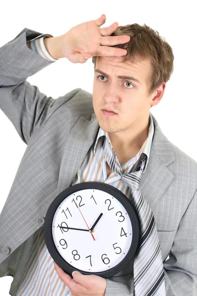 Tired businessman in grey suit holding a clock — Stock Photo, Image