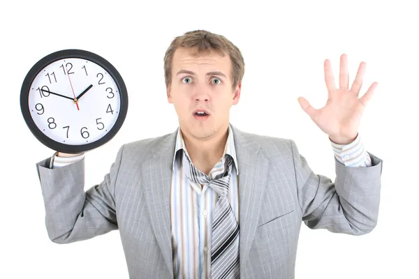 Empresário espantado em terno cinza segurando um relógio — Fotografia de Stock