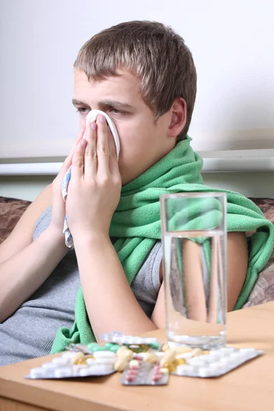 Sick man with tablets ans glass of water — Zdjęcie stockowe