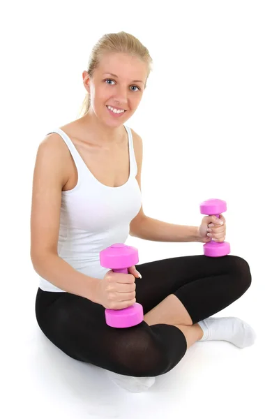 Attractive girl with dumbbells sitting isolated over white backg — Stock Photo, Image