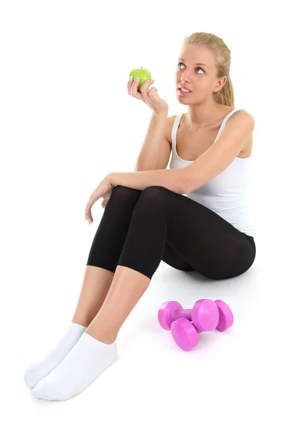 Dreaming blondie woman sitting with dumbbells and apple — Stock Photo, Image