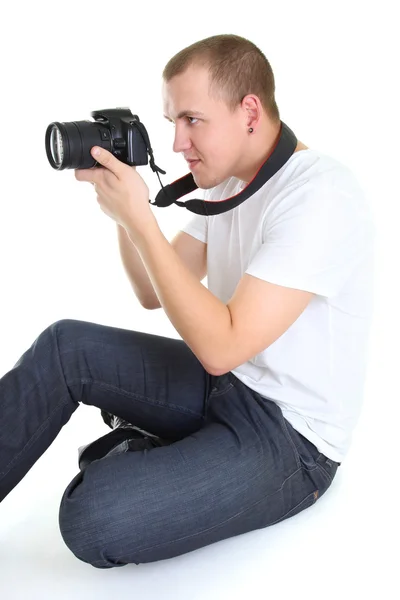 Φωτογράφος με dslr φωτογραφική μηχανή συνεδρίαση απομονωμένος πάνω από λευκό — Φωτογραφία Αρχείου