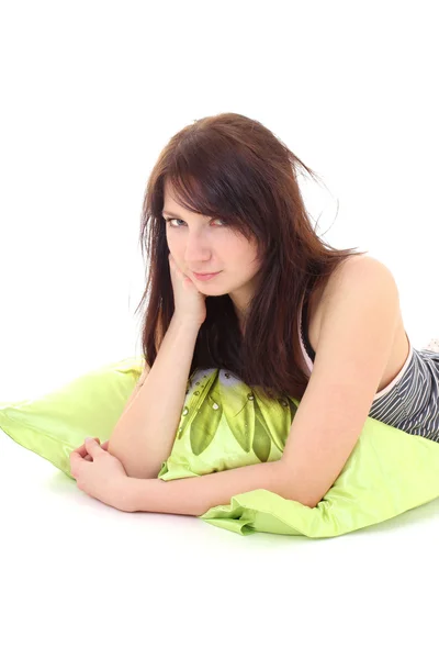 Träumen Mädchen im Schlafanzug mit grünen Kissen liegend — Stockfoto