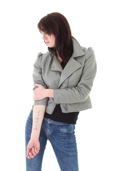 Kvinna i jeans och läder jacka visar hennes tatuering — Stockfoto