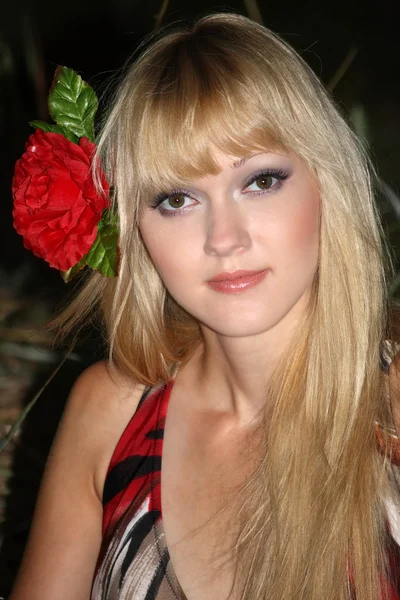 Portrait d'une femme blonde avec une fleur dans les cheveux — Photo