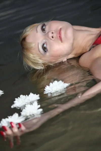 Mujer rubia acostada en el agua — Foto de Stock