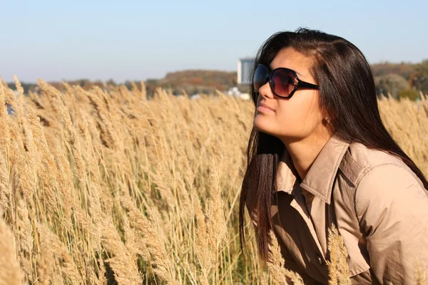 Mujer en abrigo otoño amarillento y gafas de sol — Foto de Stock