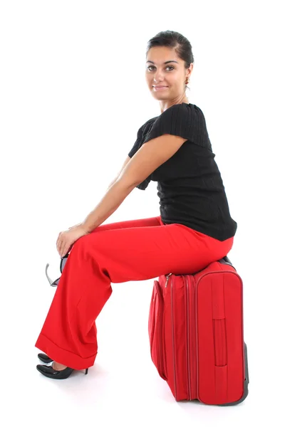 Kobieta siedzi na duży czerwony walizka — Zdjęcie stockowe