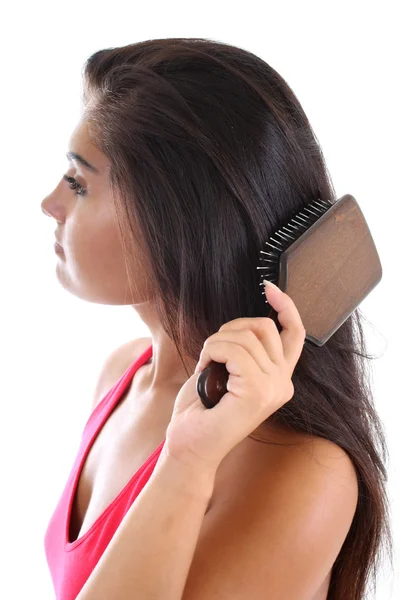 Mujer joven cepillándose el pelo — Foto de Stock