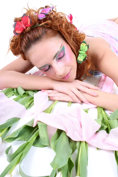 Рыжеволосая женщина с бабочками на ее голове лежа — стоковое фото