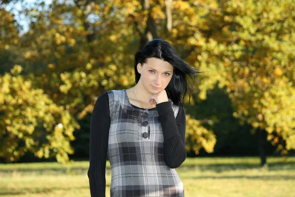 Dziewczyna w kratkę sukienka w parku jesień — Zdjęcie stockowe