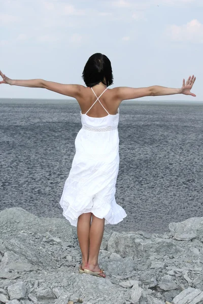 Attraktiv kvinna på en stenig strand — Stockfoto