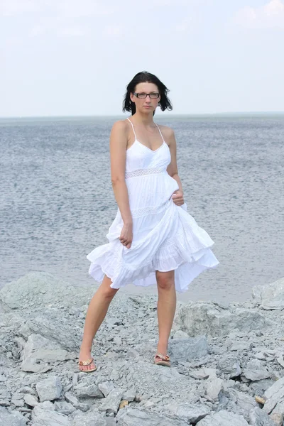 Atraktivní žena na skalnaté pláži — Stock fotografie