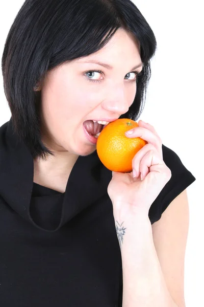 Jonge mooie vrouw bijten oranje — Stockfoto