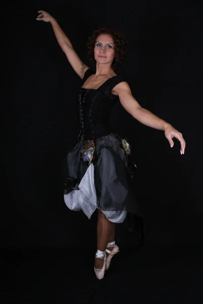 Балерина в чорне плаття на темному тлі — стокове фото