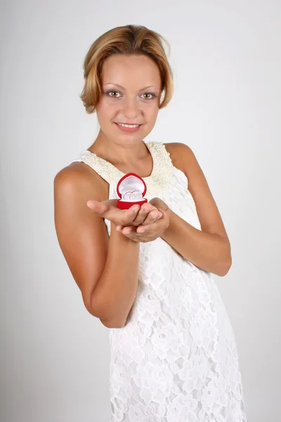 Nevěsta drží snubní prsteny v červené pole. zaměřit se na kroužky — Stock fotografie