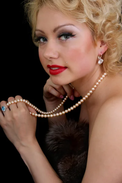 Blondie kvinna med pärlhalsband i hand — Stockfoto