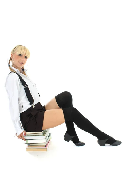 Studentessa seduto sui libri impilati — Foto Stock