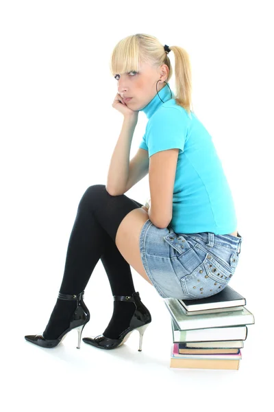 Menina triste sentado sobre os livros empilhados — Fotografia de Stock