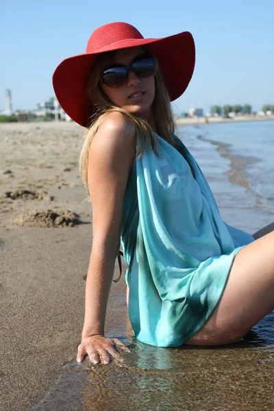 Glad ung kvinna i badkläder, solglasögon och röd hatt — Stockfoto