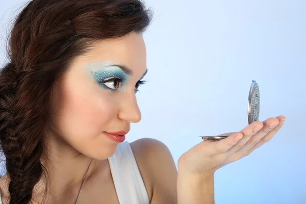 Krásná žena s make-up při pohledu na zrcadlo Stock Obrázky