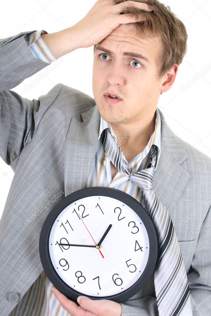 Amazed businessman in grey suit holding a clock