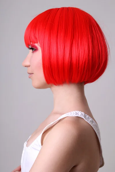 Профиль молодой женщины в красный парик — стоковое фото