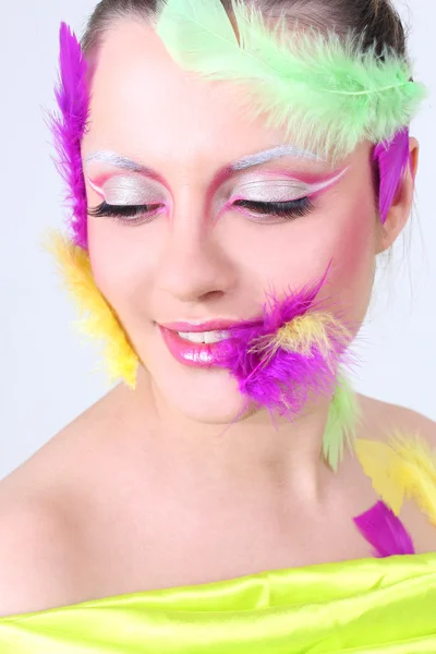 Kvinna med creative make-up och fjädrar — Stockfoto