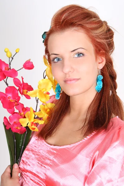 Rödhårig kvinna med gula och rosa orkidé — Stockfoto