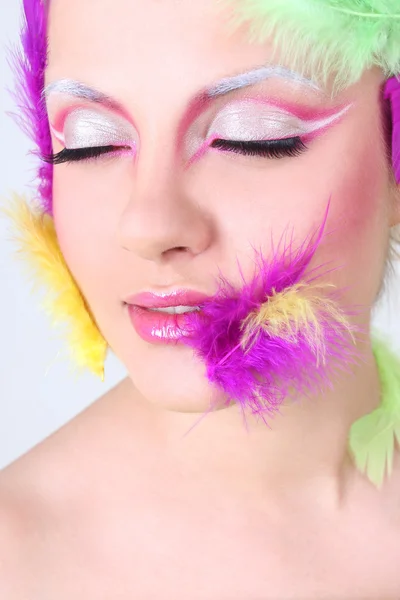 Vrouw met creatieve make-up en veren — Stockfoto
