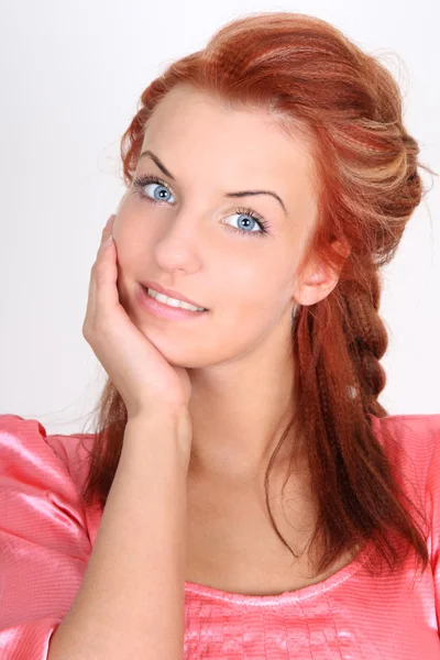 Beautiful red-haired woman in pink smiling — Stock Photo, Image