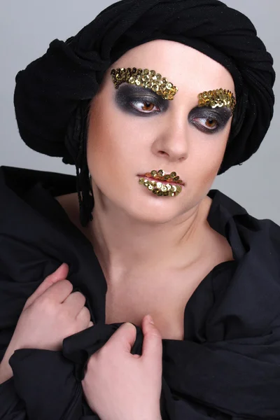 Vrouw met zwarte make-up en sjaal — Stockfoto