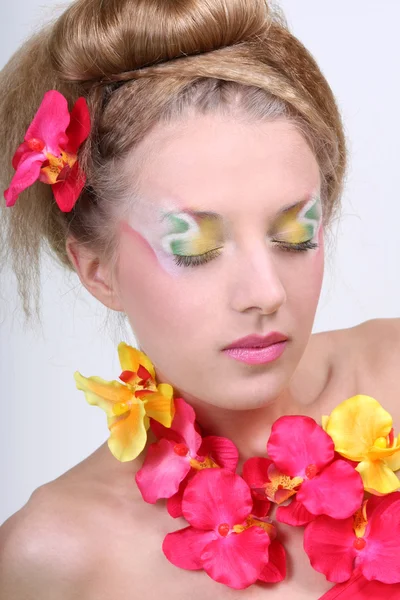 Mujer hermosa con maquillaje creativo y flores — Foto de Stock