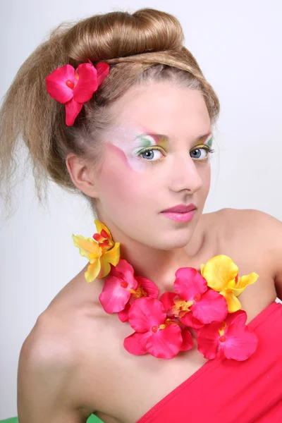 Vacker kvinna med creative make-up och blommor — Stockfoto