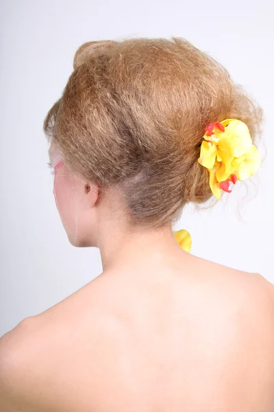 Vrouw terug met coiffure en bloemen — Stockfoto