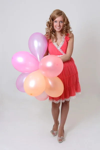 Счастливая женщина с яркими воздушными шарами — стоковое фото