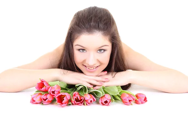 Happy girl lying with pink tulips — Stock Photo, Image