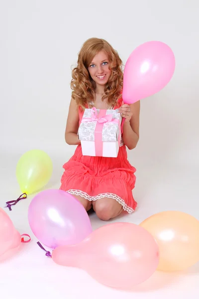 Sitting in balloons birthday girl with gift — Stock Photo, Image