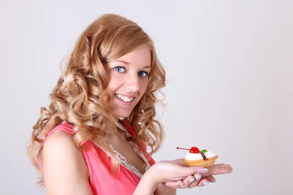 Glückliche Frau mit kleinen Kuchen in der hand — Stockfoto