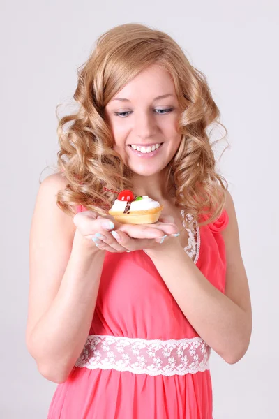 Glad kvinna med lite tårta i handen — Stockfoto