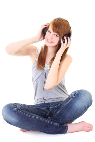 Lycklig tonåring med hörlurar som sitter — Stockfoto