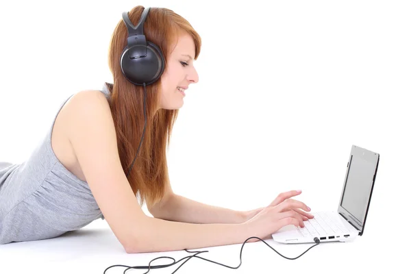 Gelukkig tiener met hoofdtelefoons en laptop liegen — Stockfoto