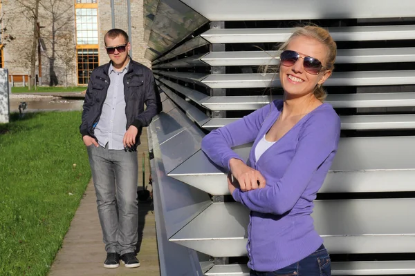 Μοντέρνο ζευγάρι στο πάρκο σε γυαλιά ηλίου που είναι χαμογελώντας — Φωτογραφία Αρχείου