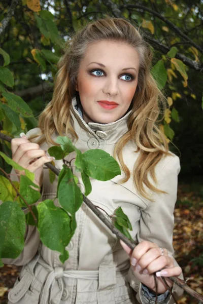 木の近くのベージュのコートを着た女性 — ストック写真