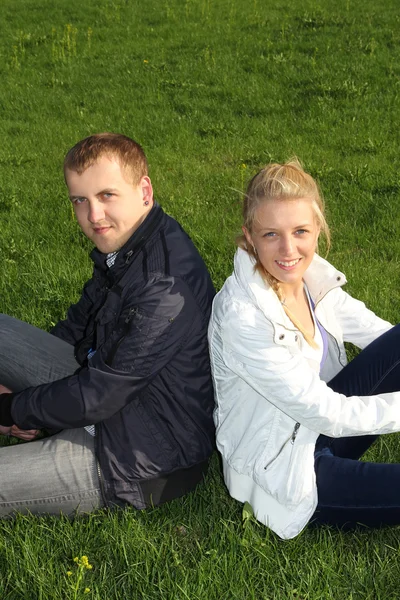 Счастливая пара сидит на траве — стоковое фото