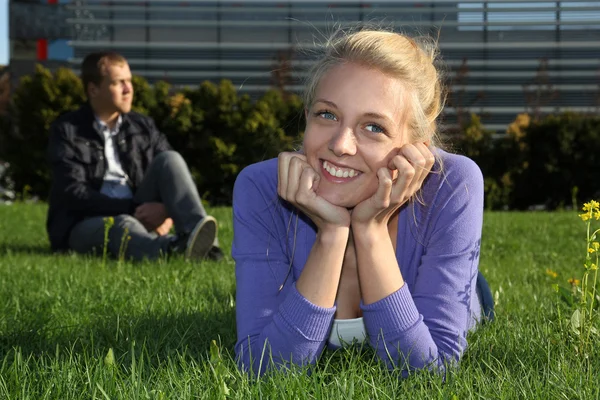 Kadın yalan ve parkta oturan adam — Stok fotoğraf